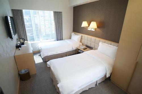 a hotel room with two beds and a window at H1 Hotel in Hong Kong