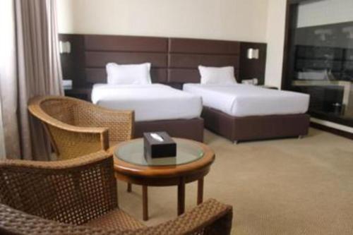 a hotel room with two beds and a table and chairs at The BCC Hotel & Residence in Nagoya