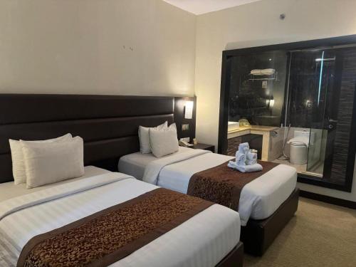 a hotel room with two beds and a window at The BCC Hotel & Residence in Nagoya