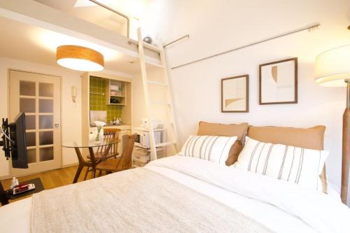 a bedroom with a white bed and a table at スカイピア高砂 201 in Tokyo