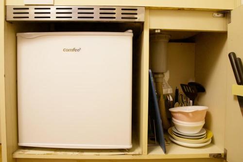 a refrigerator sitting inside of a cabinet with utensils at スカイピア高砂 201 in Tokyo