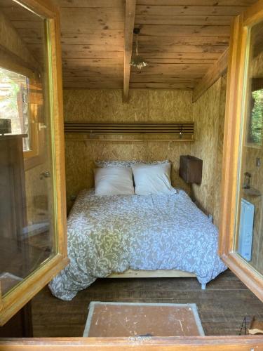 Ce lit se trouve dans une petite chambre dotée de murs en bois. dans l'établissement Le Cabanon d 'Aix, à Aix-en-Provence