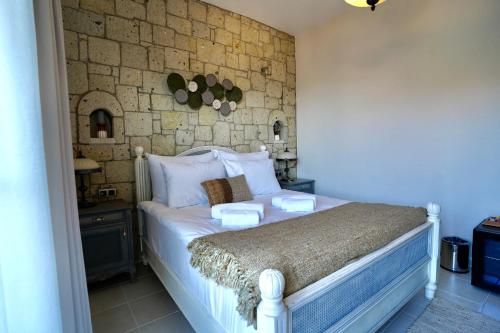 a bedroom with a white bed with two plates on it at Cumbalıca Flora in Cesme