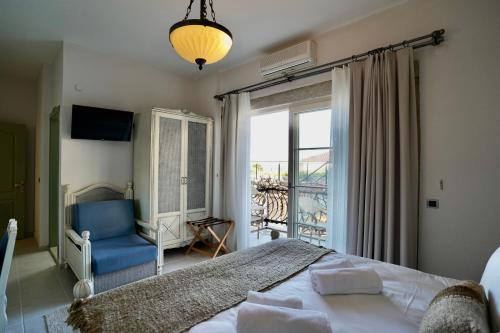 a bedroom with a bed and a blue chair and a window at Cumbalıca Flora in Cesme