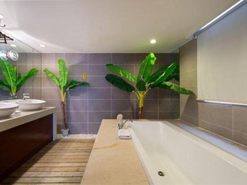 a bathroom with a tub and a sink and two sinks at Nanning Sanzan Hotel in Nanning