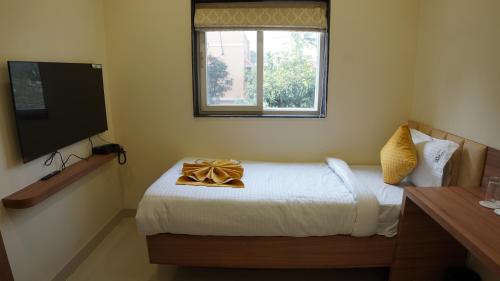 a bedroom with a bed and a window and a television at ARK Hotels in Rānchī