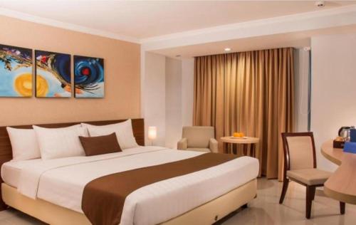 a hotel room with a large bed and a desk at Bogor Valley Hotel in Bogor