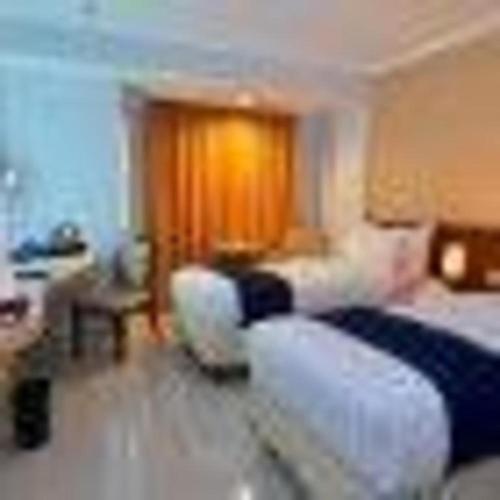 a bedroom with a bed and a living room at Bogor Valley Hotel in Bogor