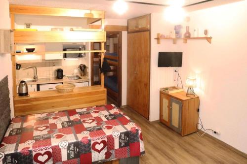 Cette petite chambre comprend un lit et une cuisine. dans l'établissement Résidence Le Cairn - Studio 4 personnes 1650 MAE-0874, à Le Mélézet