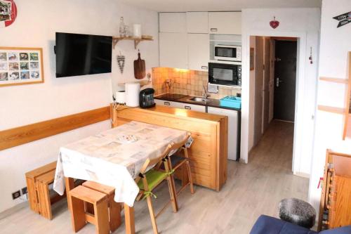 une cuisine avec une table et une petite cuisine avec une cuisinière dans l'établissement Résidence Le Cairn - Studio 4 personnes en cœur de station MAE-4914, aux Orres