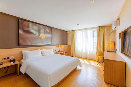 a bedroom with a large white bed and a large window at IU Hotel Tianjin Tianta Scenic Spot Wujiayao Metro Station in Tianjin