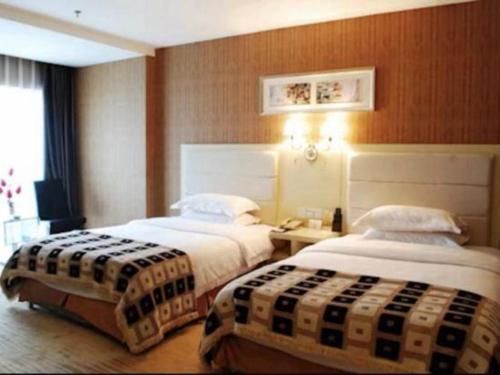 a hotel room with two beds in a room at Chengdu Huadu Times Hotel in Chengdu
