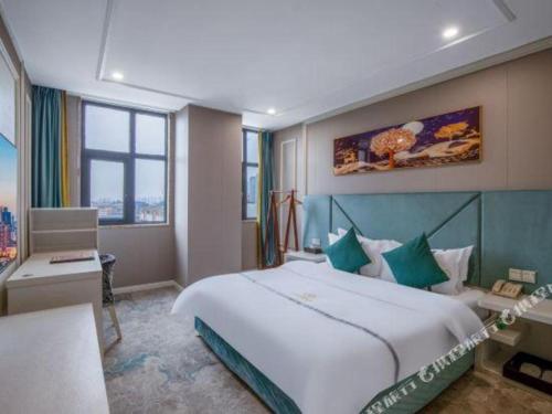 a hotel room with a large bed and a desk at Chengdu Huadu Times Hotel in Chengdu