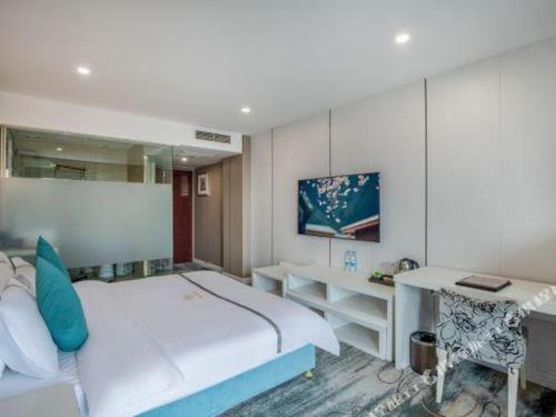 a bedroom with a large bed and a desk at Chengdu Huadu Times Hotel in Chengdu