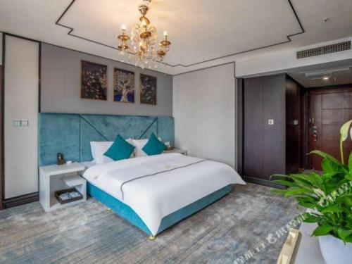 a bedroom with a large bed and a chandelier at Chengdu Huadu Times Hotel in Chengdu