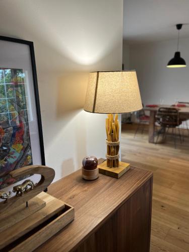 - une lampe au-dessus d'une table en bois dans une chambre dans l'établissement Villa tara, à Fayence