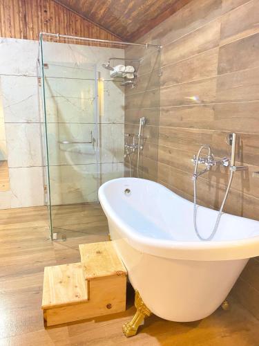 a bathroom with a tub and a glass shower at Maharanee Bungalow Darjeeling in Darjeeling