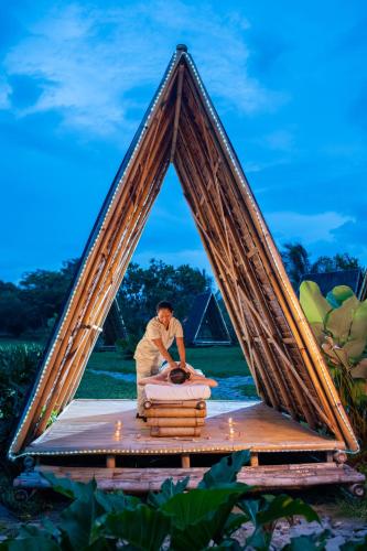 a man making a bed in a triangular frame at Astoria Palawan in Puerto Princesa City