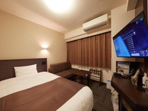 a hotel room with a bed and a flat screen tv at Hotel Sealuck Pal Yaizu in Shizuoka