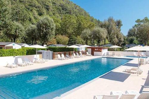 une grande piscine avec chaises et parasols dans l'établissement Camping 4 étoiles - Piscine - ccb0eab, à La Colle-sur-Loup