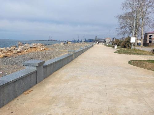 a sidewalk next to a beach with a retaining wall at квартира in Poti