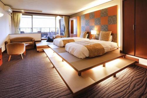a hotel room with two beds and a couch at Kyoto Keburikawa Hotel in Kameoka