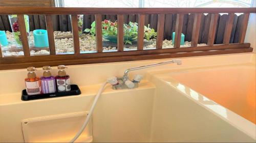 a bathroom with a sink and a window at Hotel Miyama in Chichibu