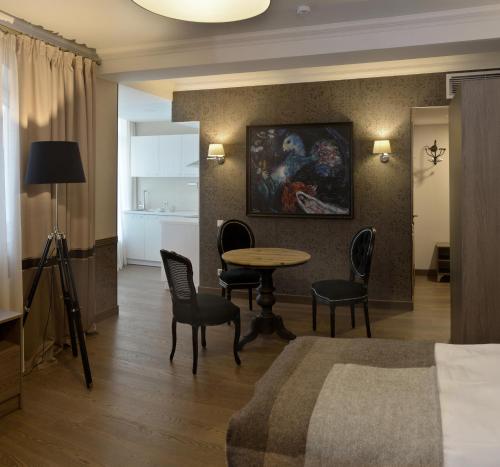 a hotel room with a table and chairs and a bedroom at ZENTRUM Hotel in Chişinău
