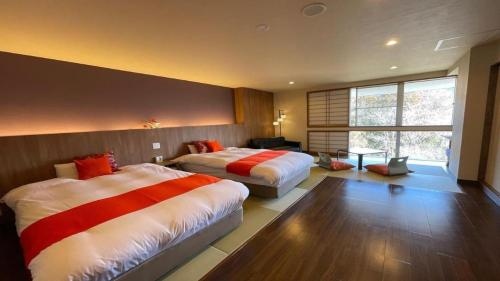 a bedroom with two beds and a table in it at Hotel Miyama in Chichibu