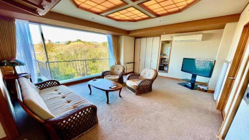 a living room with couches and a flat screen tv at Hotel Miyama in Chichibu