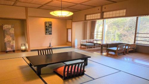 a room with a table and chairs and a dining room at Hotel Miyama in Chichibu