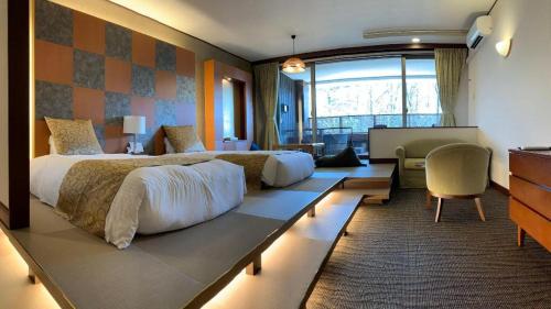 a bedroom with a large bed and a living room at Kyoto Keburikawa Hotel in Kameoka