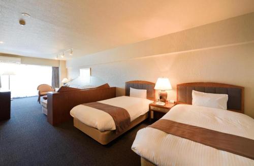 a hotel room with two beds and a window at Villa Kitakaruizawa L-Wing in Kita-karuizawa