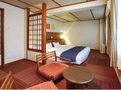 a hotel room with a bed and a table and a table sidx sidx at Kyoto Keburikawa Hotel in Kameoka
