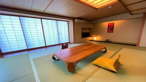 a living room with a wooden table and a chair at Hotel Miyama in Chichibu
