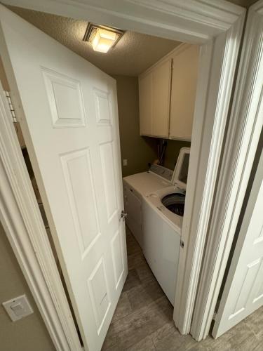 an open door to a laundry room with a washer and dryer at Riverside Views & Pool Retreat in Riverside
