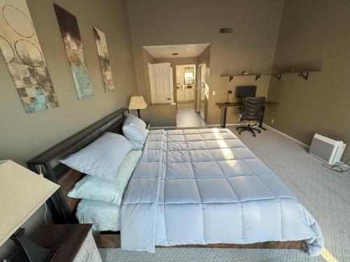 a bedroom with a large bed and a desk at Riverside Views & Pool Retreat in Riverside