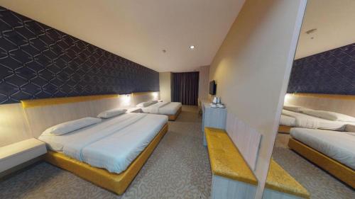 a hotel room with three beds in a room at Clover Hotel in Johor Bahru