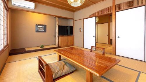 a living room with a wooden table and chairs at Yukemuri no sato azumaya in Beppu