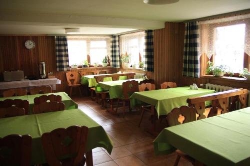 une salle à manger avec des tables et des chaises vertes dans l'établissement Limba, à Bukowina Tatrzańska