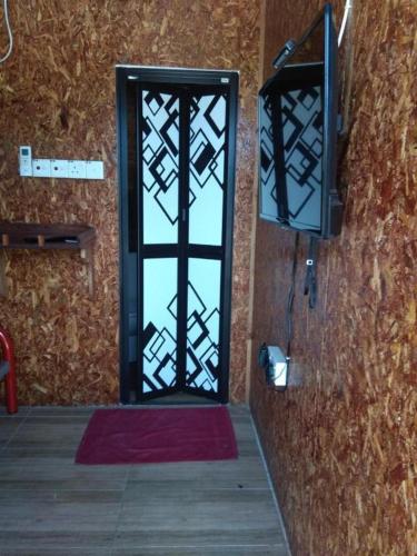 a door to a room with a red rug and a window at MyDesaStay in Sekincan