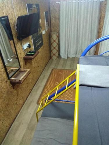 a room with two beds and a mirror and a tv at MyDesaStay in Sekincan