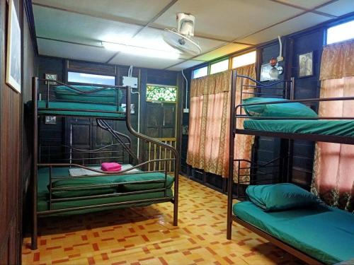 a room with three bunk beds in a room at MyDesaStay in Sekincan