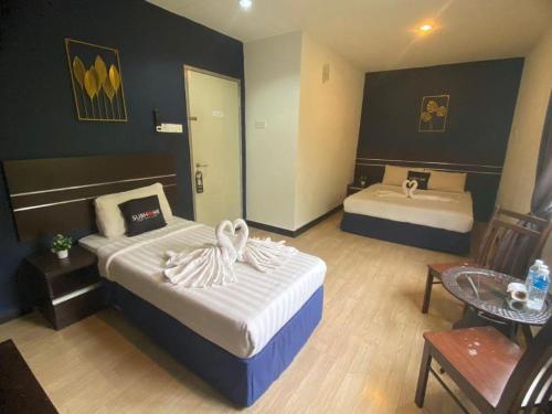 a hotel room with two beds and a sink at Alia Express Sendayan in Seremban