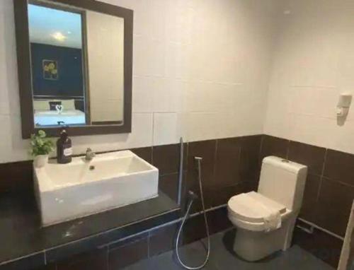 a bathroom with a sink and a toilet and a mirror at Alia Express Sendayan in Seremban