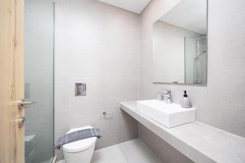a white bathroom with a sink and a toilet at Villa Salty Sun 2 in Kremasti