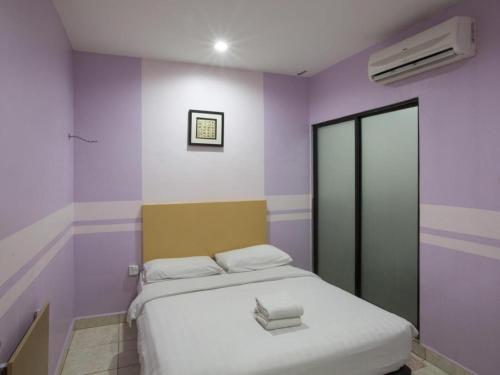 a bedroom with purple and white walls and a bed at Hotel Zamburger Sri Petaling in Kuala Lumpur