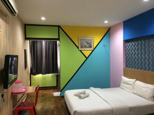 a room with a bed with a colorful wall at Hotel Zamburger Sri Petaling in Kuala Lumpur