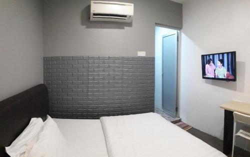 a bedroom with a bed and a tv on the wall at Hotel Zamburger Bentong in Bentong