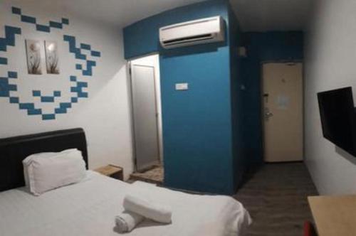 a room with a bed and a blue wall at Hotel Zamburger Bentong in Bentong
